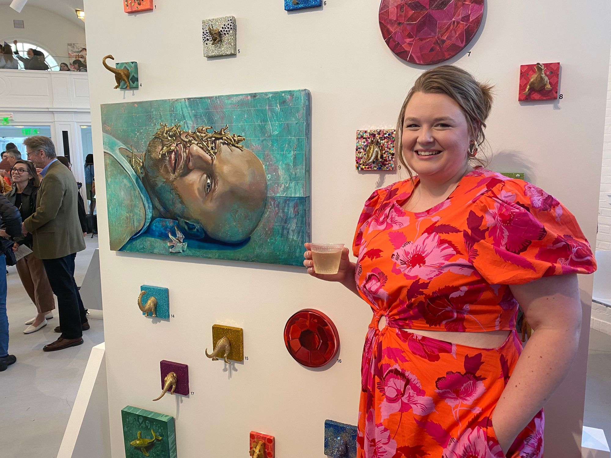 A woman poses in front of a piece of art