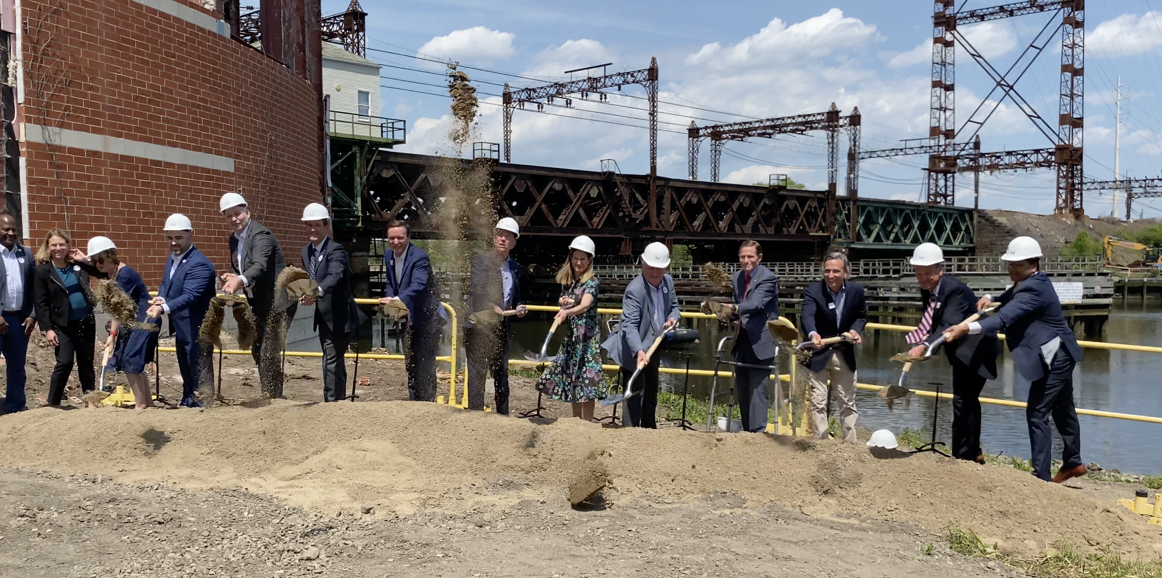 Officials dig shovels into the ground